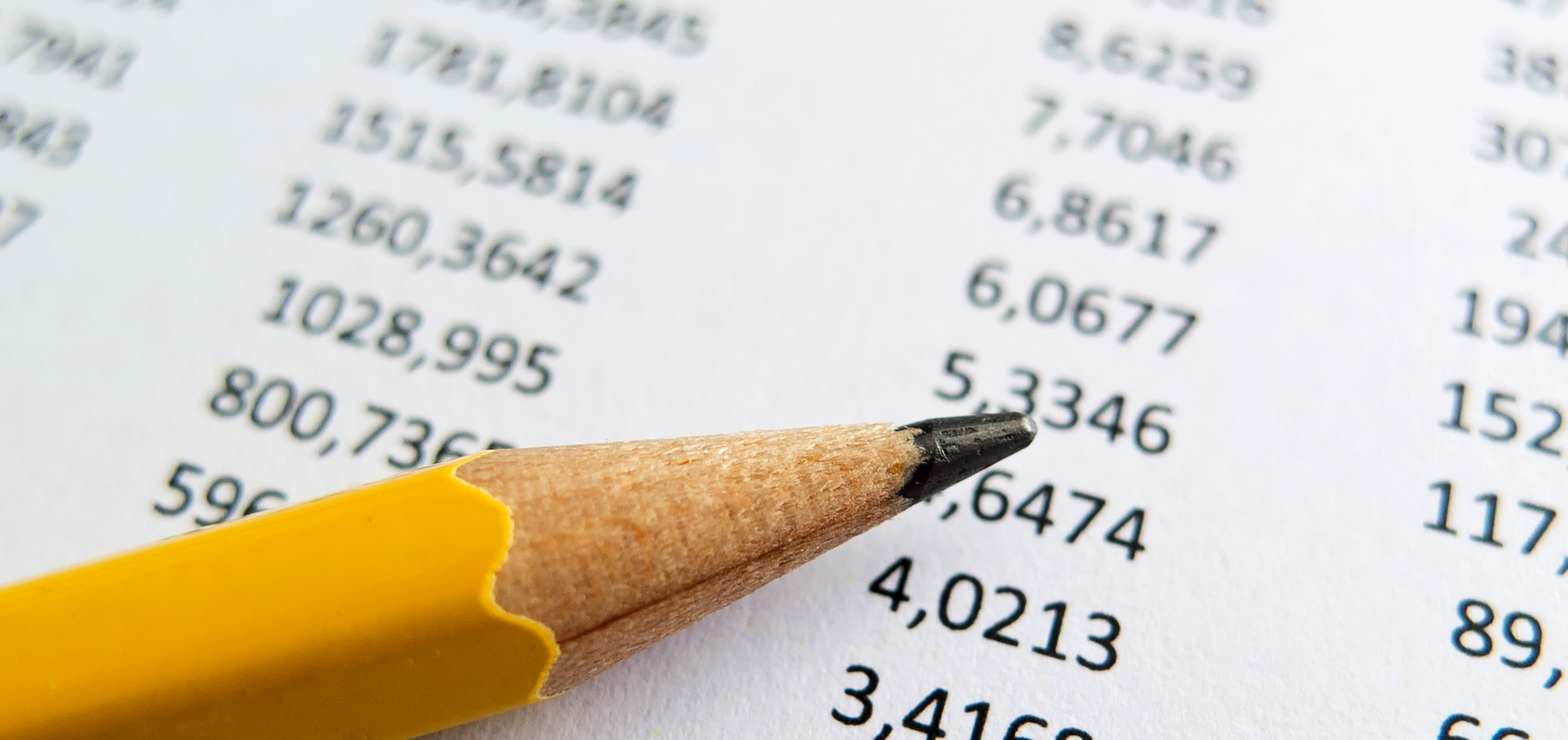 A pencil pointing to figures in a financial report